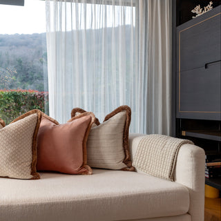 Beige sofa with decorative pillows in a living room setting