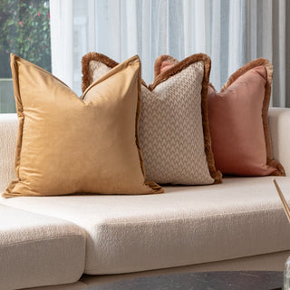 Beige sofa with decorative pillows and a flower arrangement on a patio