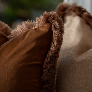 Close-up of brown textured pillows with brown fringe