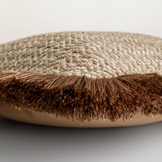 Round brown cushion with textured surface on a light gray background