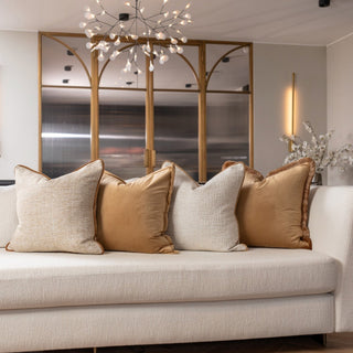 Beige sofa with decorative pillows in a modern living room setting.