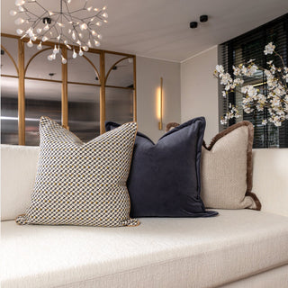 Three decorative pillows on a white sofa with a modern interior background