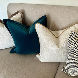 Decorative pillows on a beige sofa with a neutral background